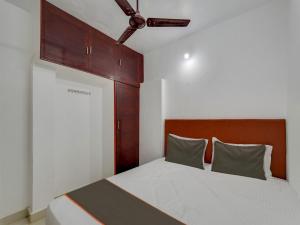 a bedroom with a bed with a wooden headboard at Collection O Anu Villas in Chennai
