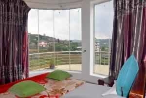 a bedroom with a bed and a large window at Nuwaraeliya Konical Villa in Nuwara Eliya