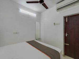 a bedroom with a bed with a ceiling fan and a door at Collection O Anu Villas in Chennai