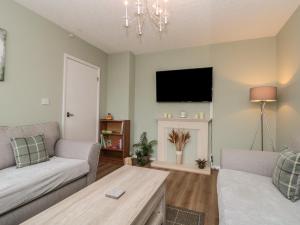 een woonkamer met een bank en een tv bij Seaside Cottage in Scarborough