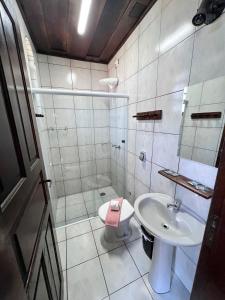 a bathroom with a sink and a toilet at Pousada Manacas in Ubatuba