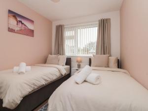 twee bedden in een kamer met een raam bij Seaside Cottage in Scarborough