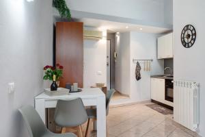 a kitchen and dining room with a white table and chairs at Casa intimissima in Imperia +5 photos