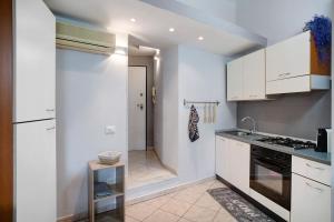 a kitchen with white cabinets and a stove at Casa intimissima in Imperia