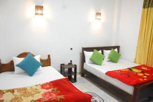 two beds in a room with two pillows at Nuwaraeliya Konical Villa in Nuwara Eliya