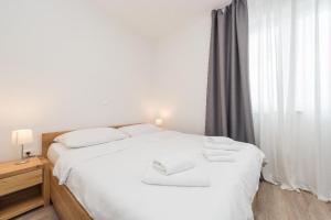 Un dormitorio con una gran cama blanca y una ventana en Villa Petar's Dream, en Privlaka
