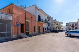 an empty street with cars parked in front of buildings at Stella di Domenica in Poggiardo