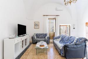 a living room with a couch and a tv at Stella di Domenica in Poggiardo