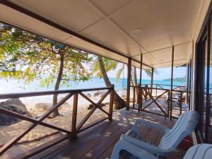 um alpendre com cadeiras e vista para a praia em Home Away Tioman Island em Ilha Tioman