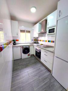 セビリアにあるEnladrillada Apartmentの白い家電製品が備わるウッドフロアのキッチン