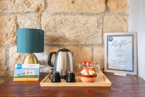 a table with a coffee pot and a lamp on it at Bari LandLord 71 - Central Rooms in Bari