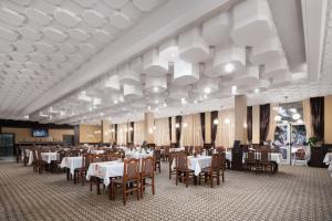 a dining room with white tables and chairs at Balneocomplex Kamena in Velingrad