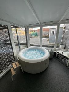 a large bath tub in a room with windows at Luxurious House in Kerkrade Center in Kerkrade