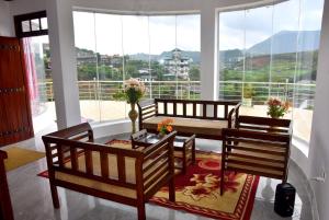 a living room with a table and chairs and a large window at Nuwaraeliya Konical Villa in Nuwara Eliya