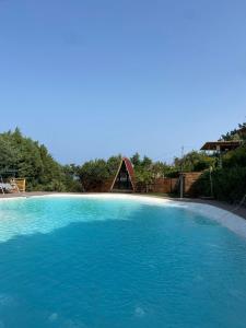 ein großer Pool mit blauem Wasser mit einem Haus im Hintergrund in der Unterkunft B&B Belvedere in Presa
