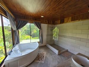 a large bathroom with a tub and a sink at Las Cotingas Ocean View in Drake