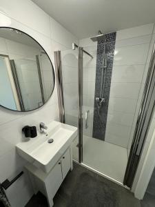 La salle de bains est pourvue d'un lavabo et d'une douche avec un miroir. dans l'établissement Luxurious House in Kerkrade Center, à Kerkrade