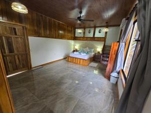 an empty room with a bed and a ceiling fan at Las Cotingas Ocean View in Drake