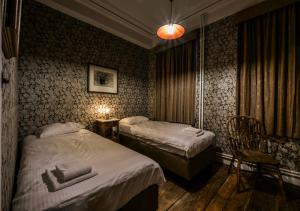 pokój hotelowy z 2 łóżkami, stołem i krzesłami w obiekcie Talbot House w mieście Poperinge