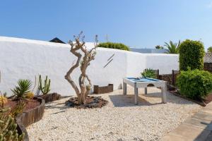 einen Garten mit einem Tisch und einem kleinen Baum in der Unterkunft Villa Marisol, Los Mojones in Tías