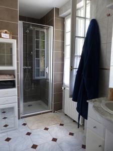 La salle de bains est pourvue d'une douche et d'un lavabo. dans l'établissement Maison d'hôtes La Source, à Magny-les-Hameaux