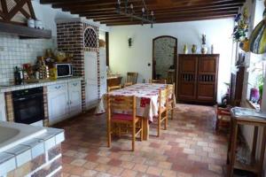- une cuisine avec une table et des chaises dans la chambre dans l'établissement Maison d'hôtes La Source, à Magny-les-Hameaux