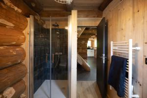 a glass shower in a bathroom with wooden walls at Gîtes en rondins de Vassivière - Les Fustes de Plazanet in Faux-la-Montagne +43 photos