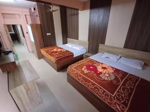 2 łóżka w pokoju hotelowym w obiekcie Shree lodge w mieście Dandeli