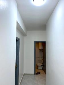 - un couloir avec des toilettes dans une chambre blanche dans l'établissement Appartement au cœur du ville, à Tanger