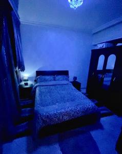 - une chambre avec un lit dans une pièce bleue dans l'établissement Appartement au cœur du ville, à Tanger
