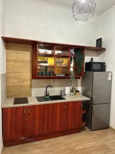 a kitchen with wooden cabinets and a stainless steel refrigerator at Wielopole Classy Rooms in Kraków