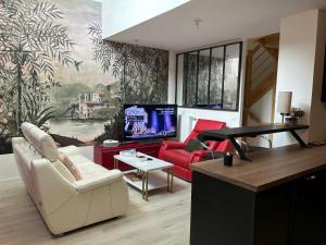 uma sala de estar com um sofá e uma televisão em DUPLEX Luxury-Appart - DYSNEY LAND PARIS em Bussy-Saint-Georges