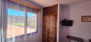 um quarto com uma janela, uma porta e uma televisão em Posada Casa de Julia em Parbayón