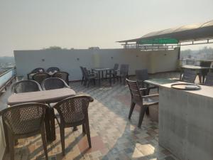 a patio with tables and chairs on a roof at Hotel Kamal Agra in Agra