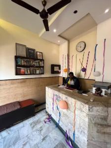 a man sitting at a reception desk in a room at Hotel Kamal Agra in Agra