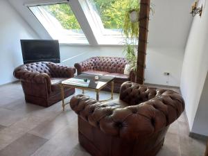 - un salon avec deux canapés en cuir et une table dans l'établissement Urlaubsoase und Meehr, à Hage