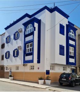 ein blau-weißes Gebäude mit einem Auto, das vorne parkt in der Unterkunft Chez Khadija Et Franz in Essaouira