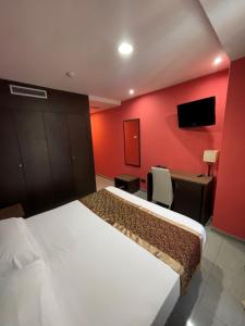a bedroom with two beds and a red wall at Hotel Ruta Romana in Sagunto