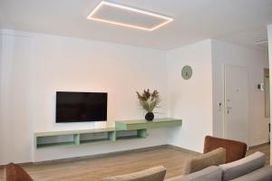 uma sala de estar com uma televisão de ecrã plano na parede em Beach Haven Hideaway - Happy Rentals em Lalzit Bay