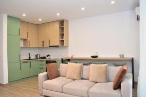 uma sala de estar com um sofá e uma cozinha em Beach Haven Hideaway - Happy Rentals em Lalzit Bay