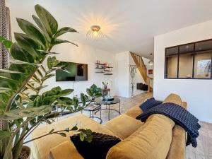 uma sala de estar com um sofá e algumas plantas em Soul Harmony Rouen maison neuve terrasse parking riviere proche docks, kindarena em Déville-lès-Rouen