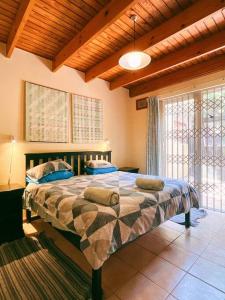 ein Schlafzimmer mit einem großen Bett mit Kissen darauf in der Unterkunft Family & pet friendly beach house, Kommetjie in Kapstadt