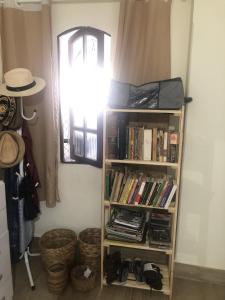 a book shelf with books in a room with a window at Quarto privativo Sanilda in Vitória