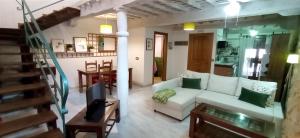 a living room with a white couch and a television at Dúplex Ca tío Celso in San Esteban de la Sierra