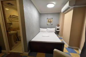 een kleine kamer met een bed in de hoek bij Remedios Hotel in Manilla