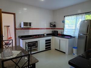 uma cozinha com um frigorífico e um fogão forno superior em Casa temporada em Arraial do Cabo