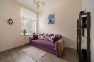 a living room with a purple couch and a window at Brīvdienu māja pašā Rīgas sirdī in Riga