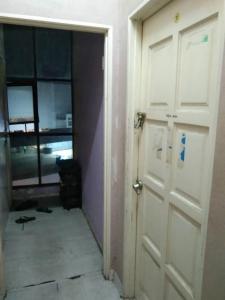 an empty room with a white door and a window at Hostel Dena moon inn 3 in Kota Bharu