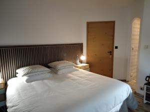 a bedroom with a large white bed with two pillows at Chambres d'Hôtes Villa Aquitaine in Bretagne-de-Marsan