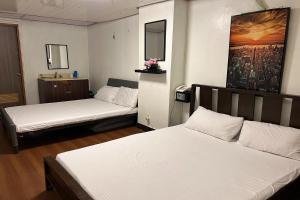 a room with two beds in a room with at Remedios Hotel in Manila